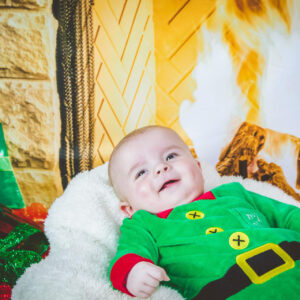 Baby smiling while wearing the Christmas Elf all-in-one